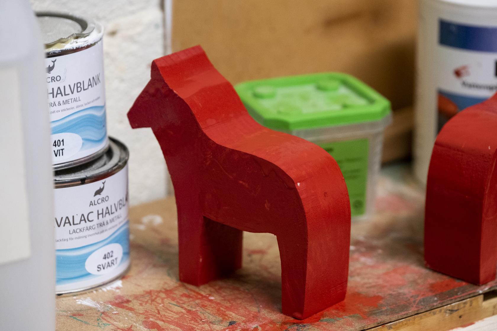 En nymålad röd trähäst.