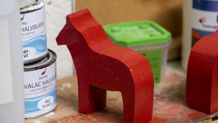 En nymålad röd trähäst.