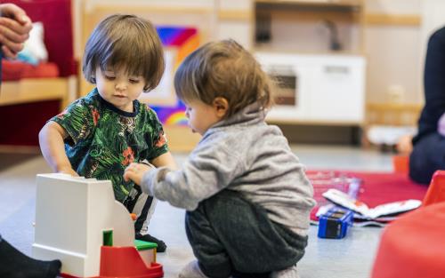 Två barn samspelar vid en leksaks-kassaapparat.