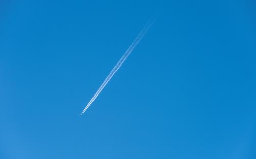 Spår av ett flygplan på den blåa himlen.
