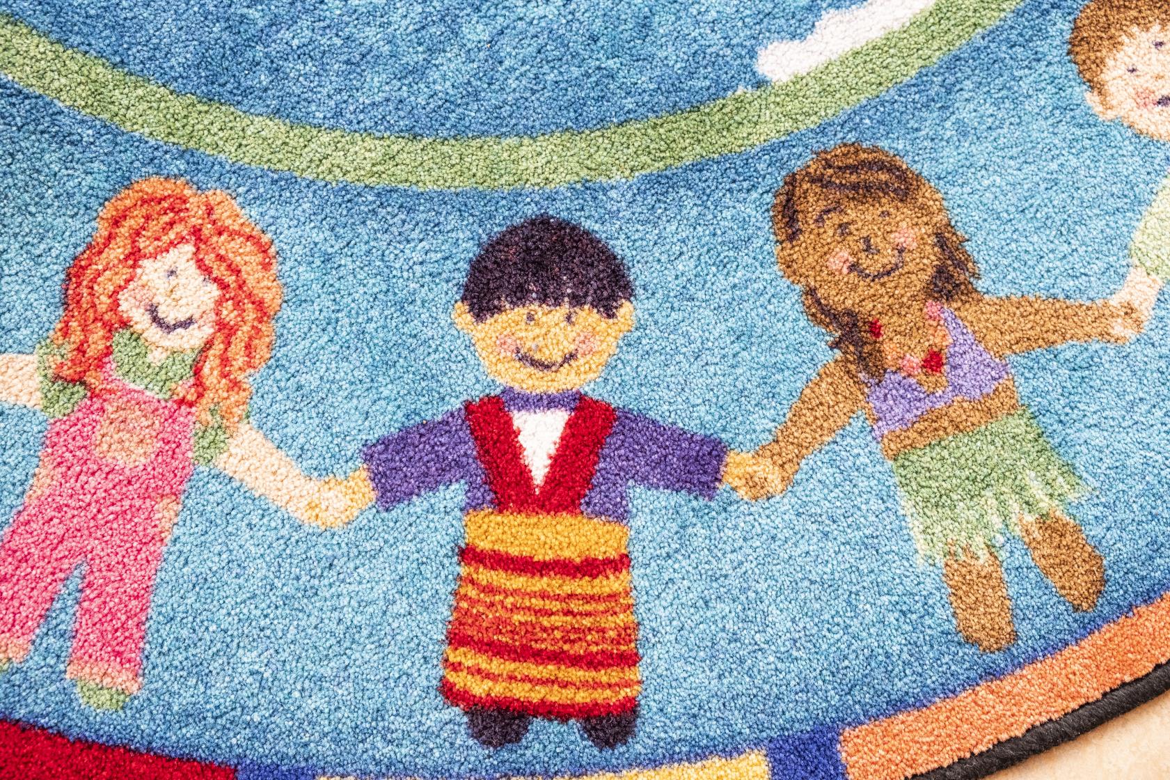 En färggrann matta med barn som håller hand som motiv.