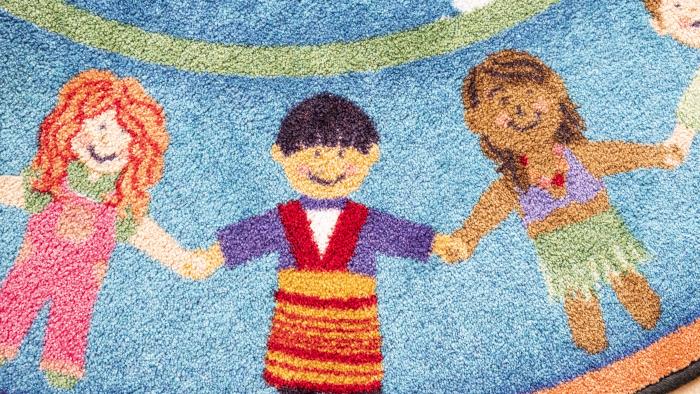 En färggrann matta med barn som håller hand som motiv.
