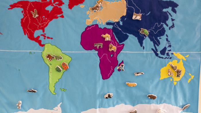 En färggrann världskarta med små djur placerade i de olika världsdelar de finns.