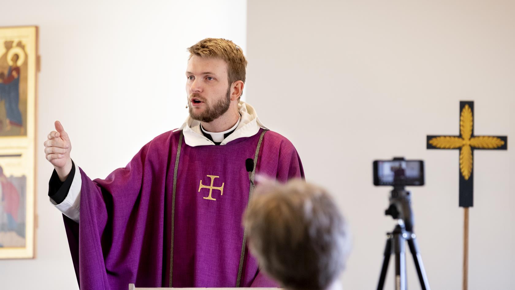 En präst predikar framför en kamera som filmar för direktsändning på webben.