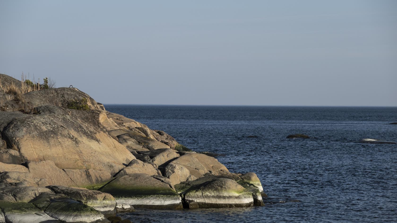 Klippor som sluttar ner mot vattnet i skärgården.