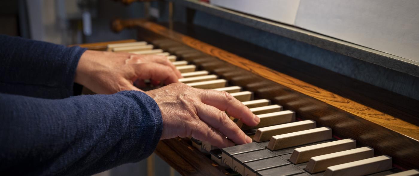 Ett par händer spelar på en kyrkorgel.