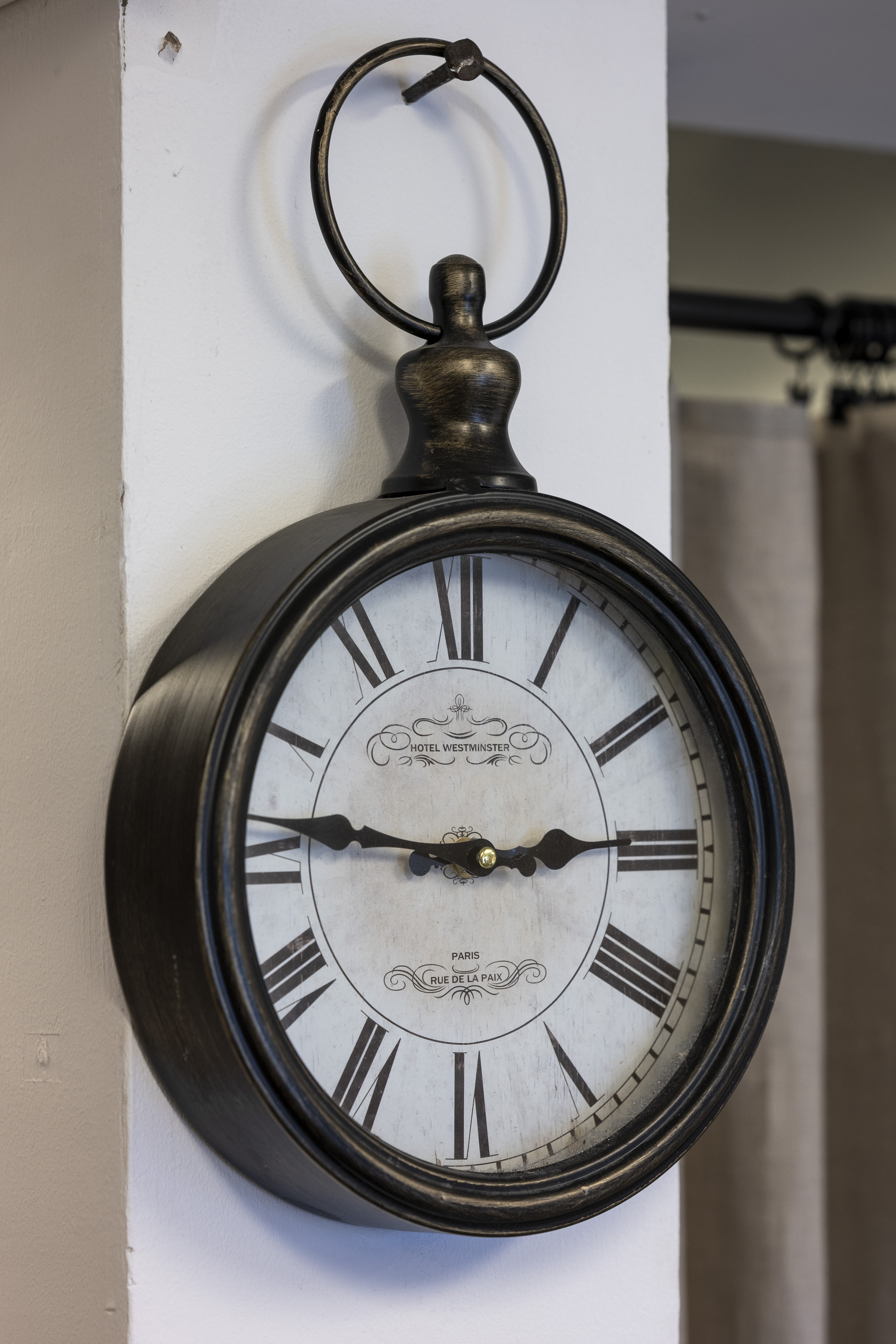 En antik klocka tänger på en spik på väggen.