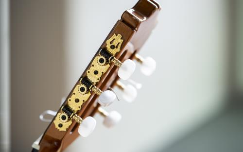 Närbild på ett gitarrhuvud till en akustisk gitarr.