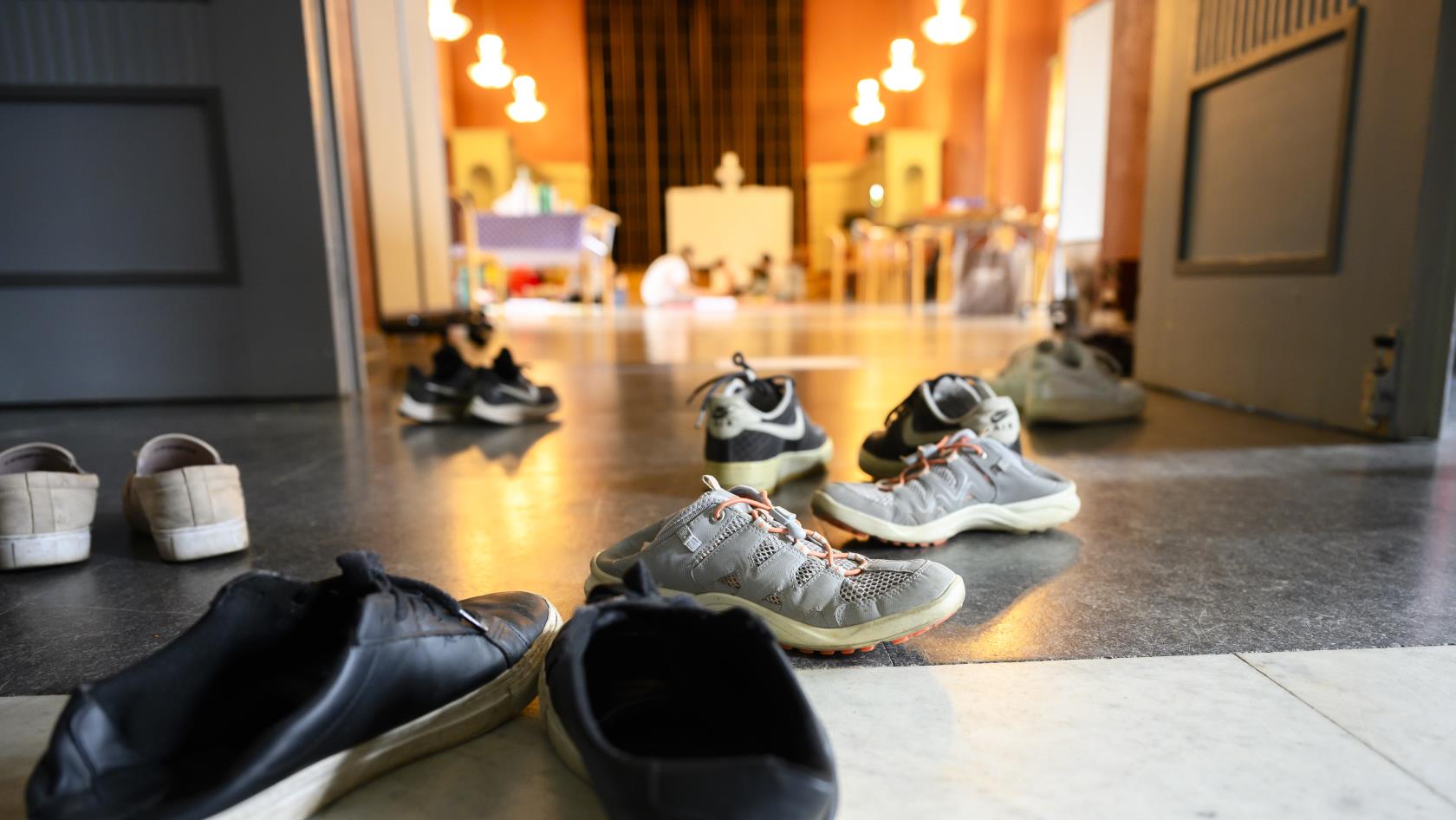 Flera par skor ligger utspridda i en hall.