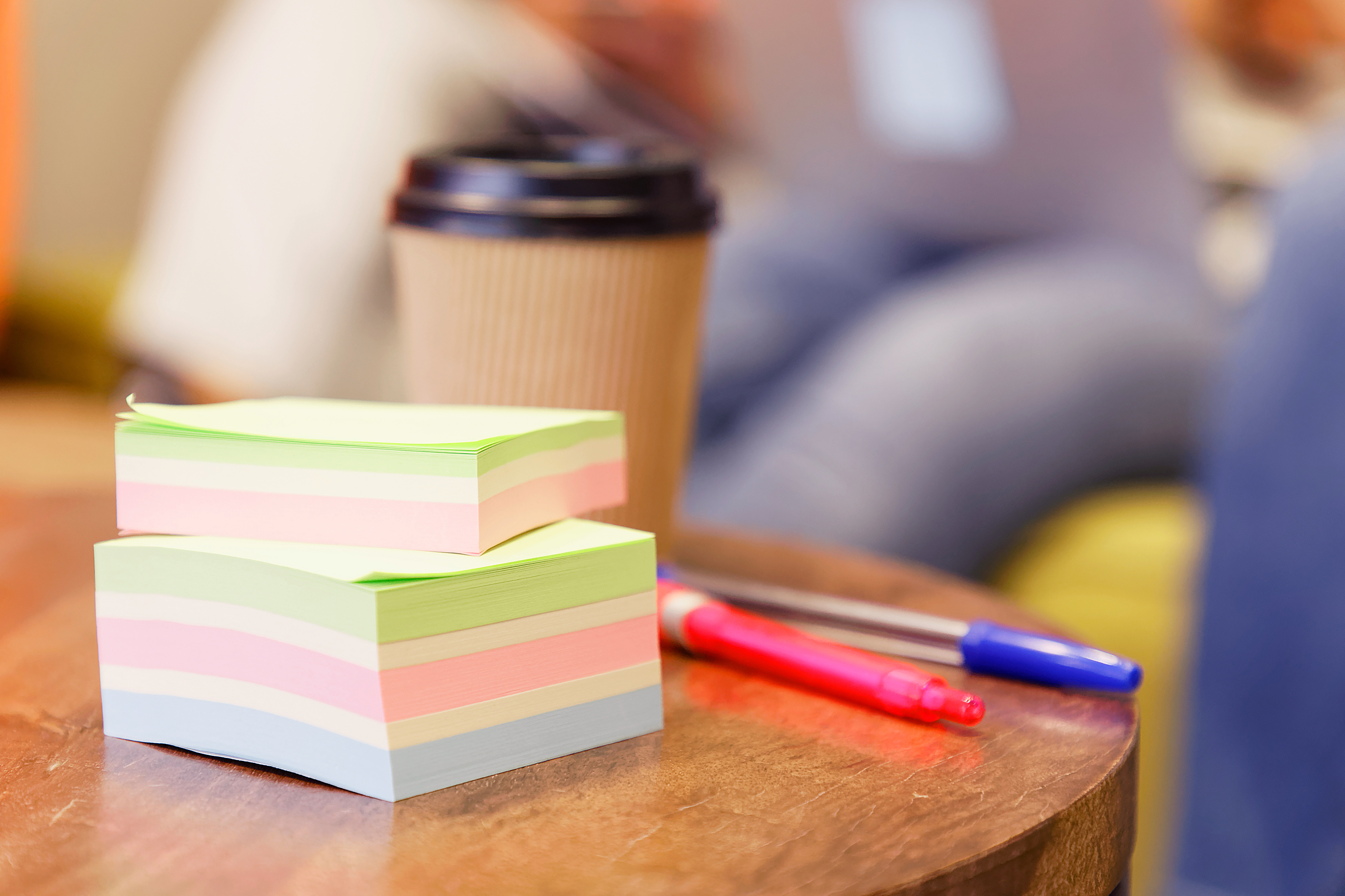 Närbild på en hög post-it-lappar och två pennor.