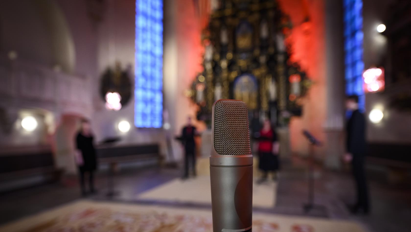 En mikrofon står uppställd för en konsert i kyrkan.