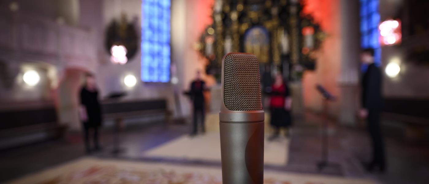 En mikrofon står uppställd för en konsert i kyrkan.