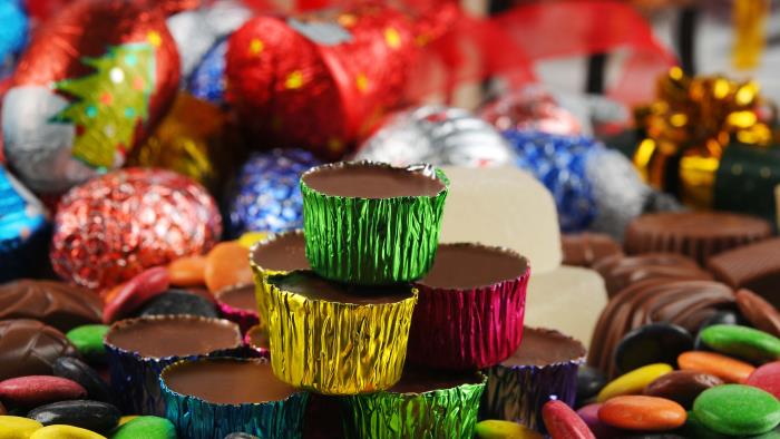 Ischoklad i färgade aluminiumformar, chokladbitar och annat julgodis.