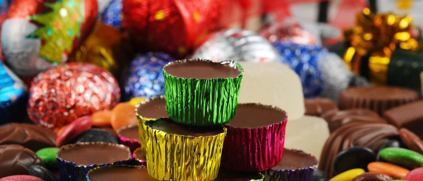 Ischoklad i färgade aluminiumformar, chokladbitar och annat julgodis.