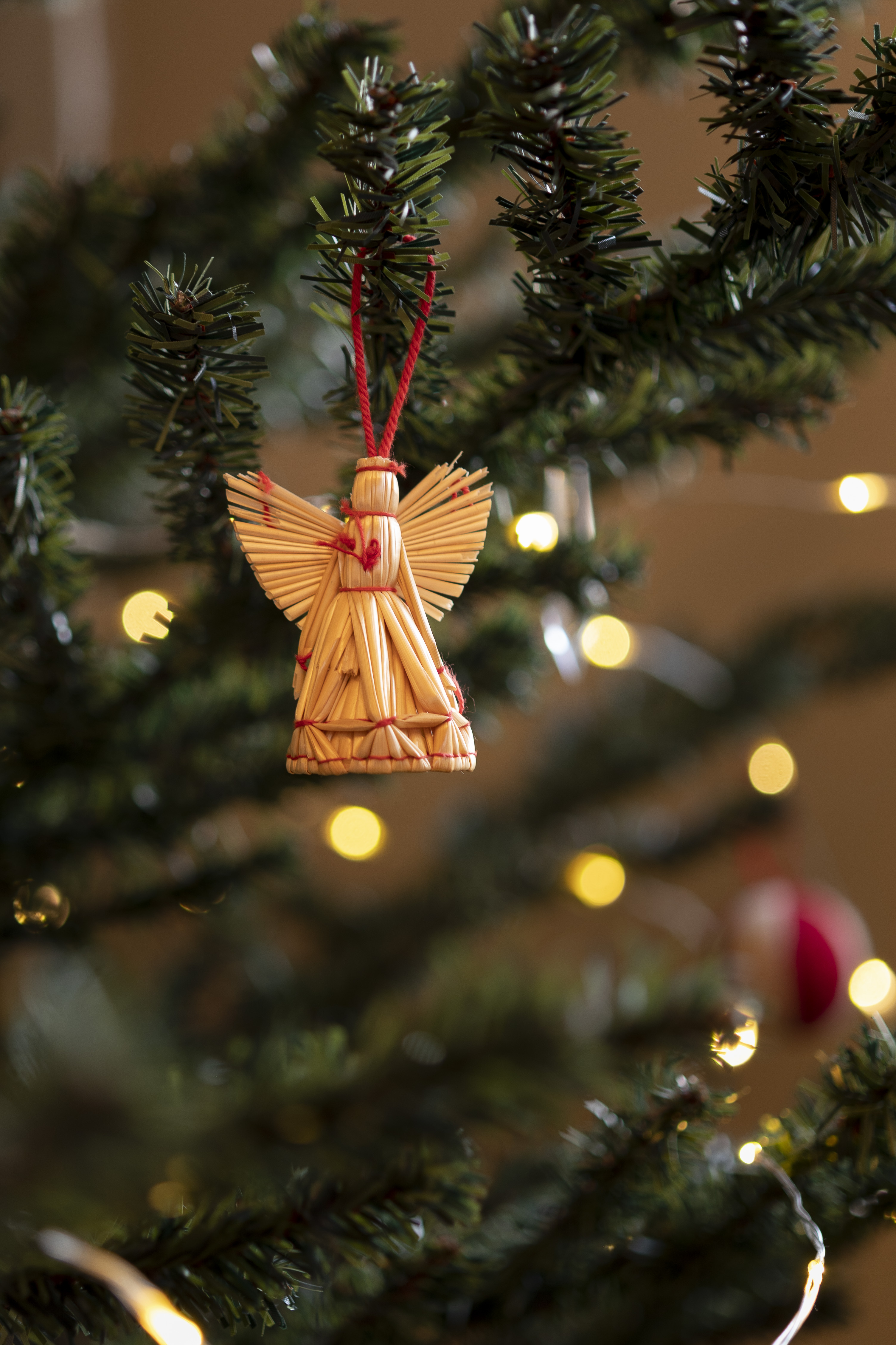 En halmängel hänger som dekoration i en julgran.