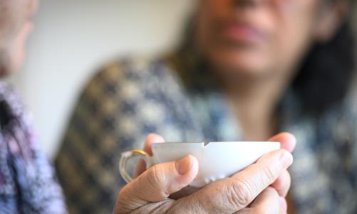 En människa som håller en kopp med en liten spricka i. 