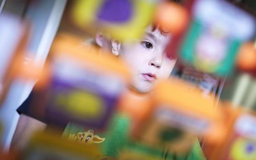 En liten flicka tittar på en leksak med olika bildmotiv.