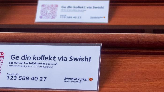 Lappar med texten Ge din kollekt via Swish ligger i kyrkbänkarna.