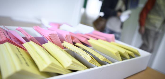 Närbild på en låda med färgsorterade röstsedlar.