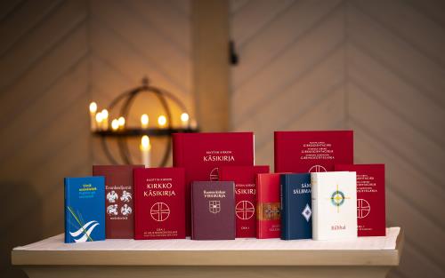 Olika kyrkliga publikationer på minoritetsspråk står uppställda på ett bord i en kyrka.