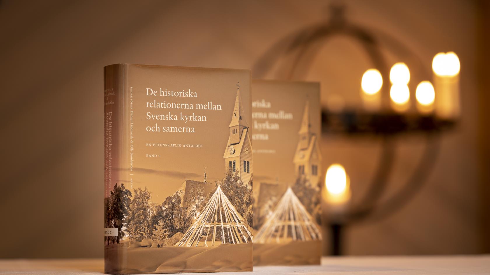 Två exemplar av boken De historiska relationerna mellan Svenska kyrkan och samerna står uppställda i en kyrka.