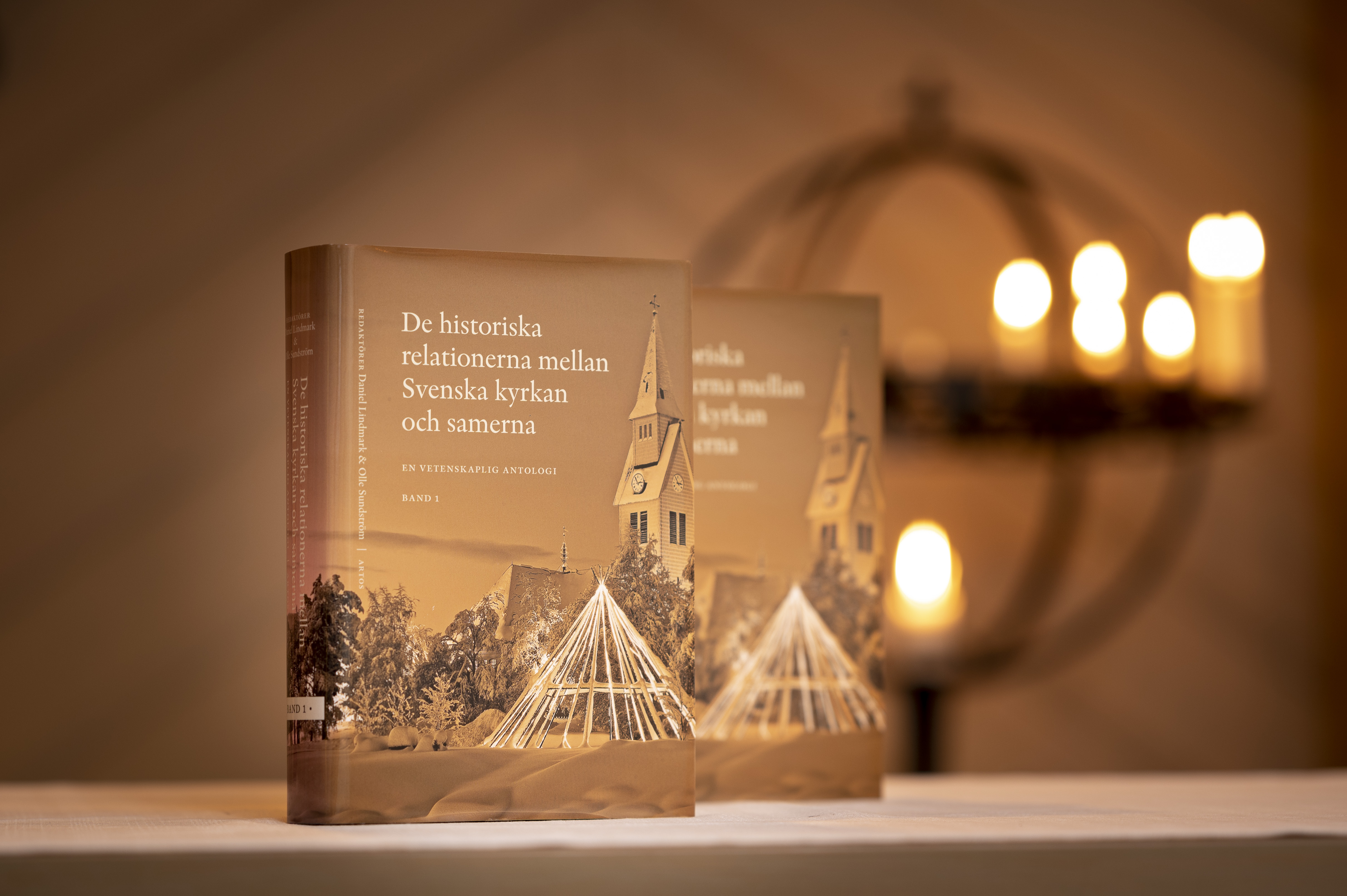 Två exemplar av boken De historiska relationerna mellan Svenska kyrkan och samerna står uppställda i en kyrka.