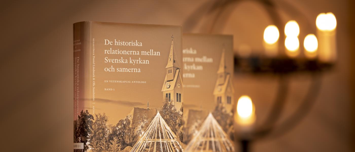 Två exemplar av boken De historiska relationerna mellan Svenska kyrkan och samerna står uppställda i en kyrka.
