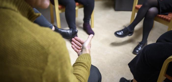 Några personer sitter och samtalar inomhus.