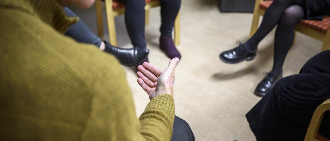 Några personer sitter och samtalar inomhus.