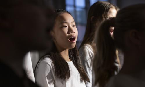 Närbild på medlemmar i en barnkör som sjunger i en kyrka.