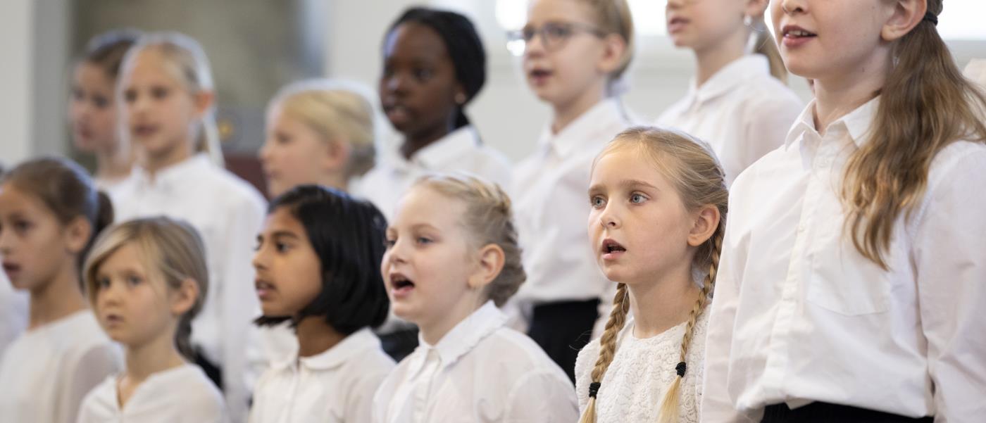 Medlemmar i en barnkör står och sjunger i en kyrka.