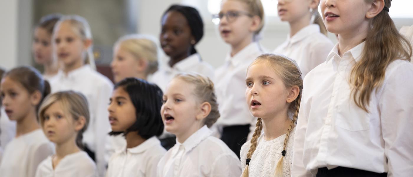 Medlemmar i en barnkör står och sjunger i en kyrka.