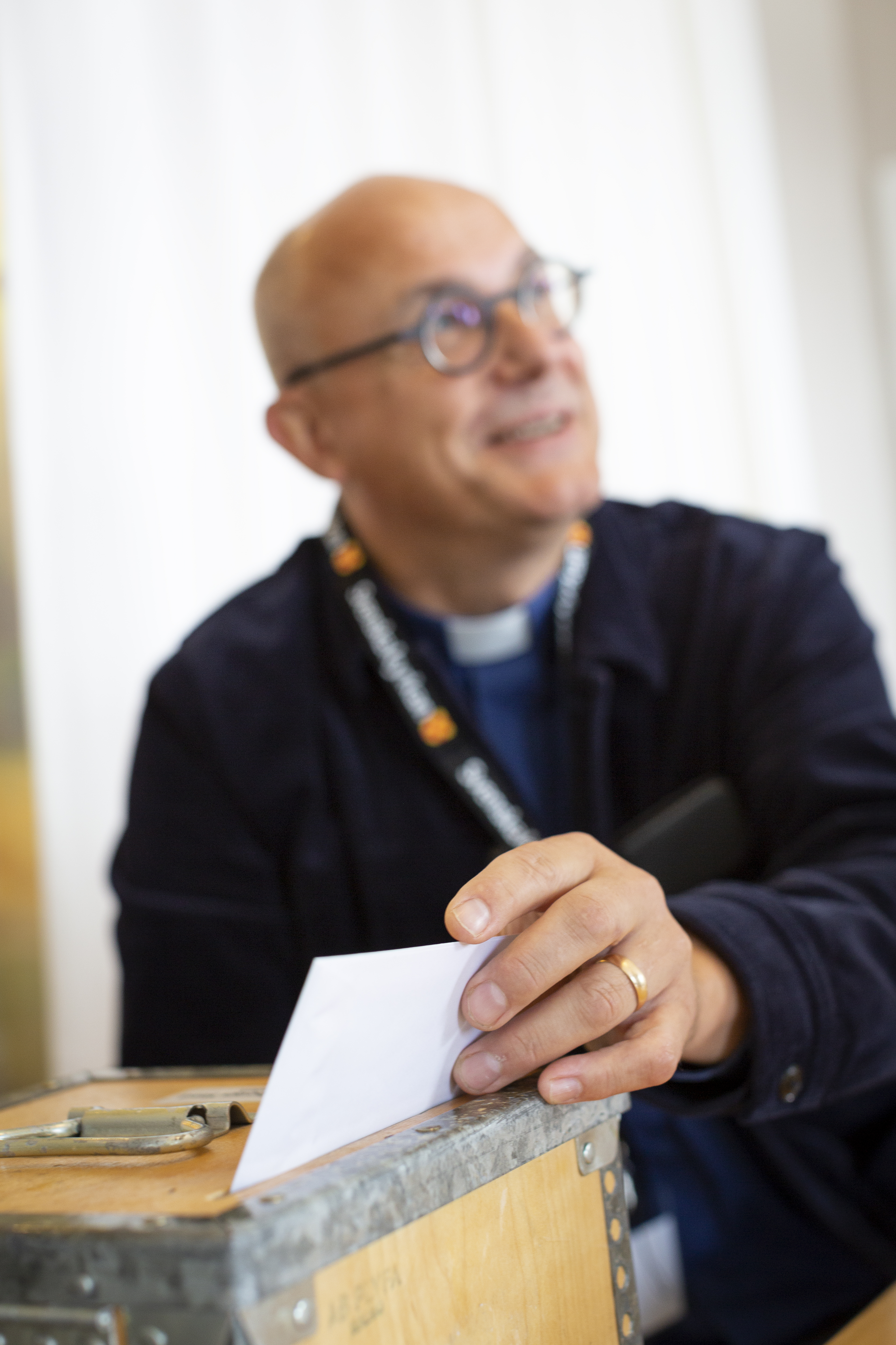 En valarbetare lägger en röstsedel i valurnan.