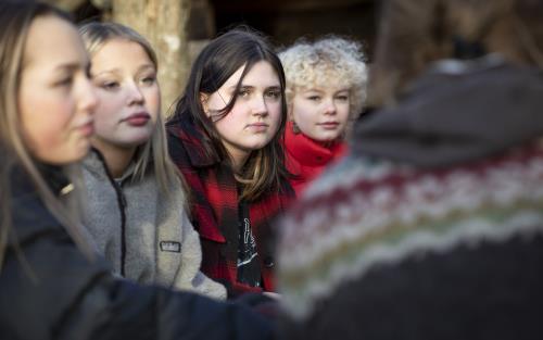 Några tonårstjejer sitter utomhus.