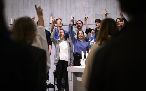 En blandad ungdomskör sjunger i en kyrka.