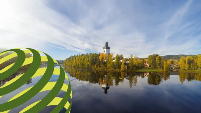 En vit landsbygdskyrka vid ett vattendrag. I ena hörnet av bilden ligger ett infällt gröngult klot.