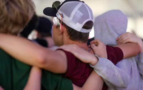 En grupp ungdomar håller om varandra i en ring.