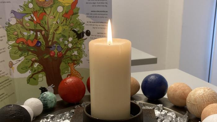 Stor version av Frälsarkransen på en bricka med tänt blockljus i mitten.