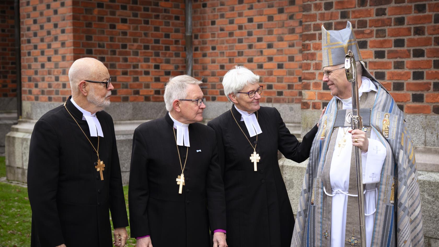 Tre tidigare ärkebiskopar, klädda i svarta kaftaner, tillsammans med nuvarande ärkebiskop Martin Modéus.