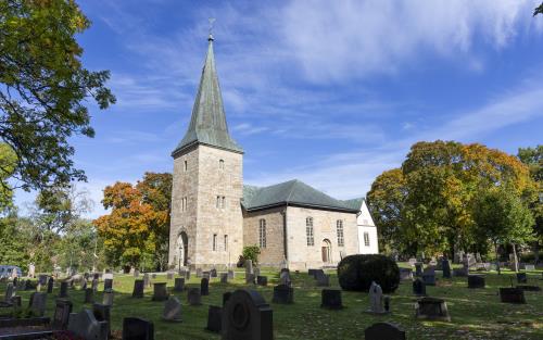 En kyrka i sandsten en solig höstdag.