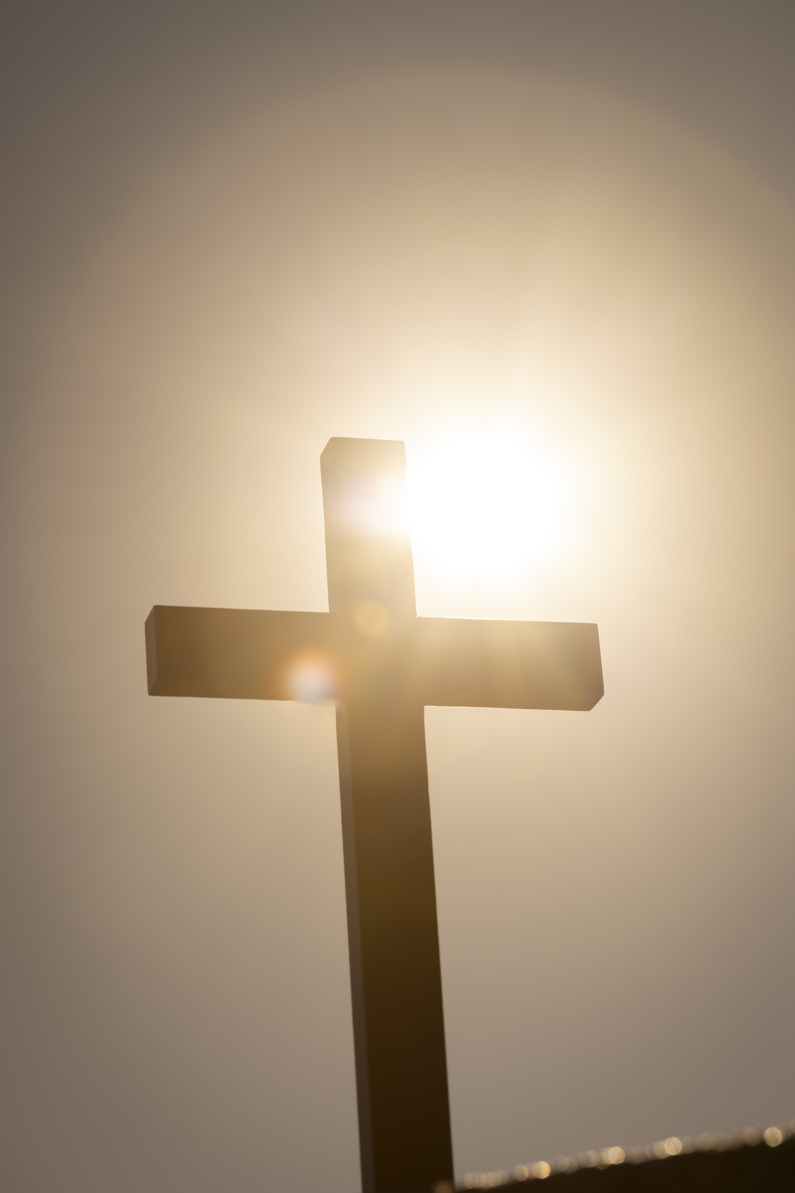 Ett enkelt kors i motljus.