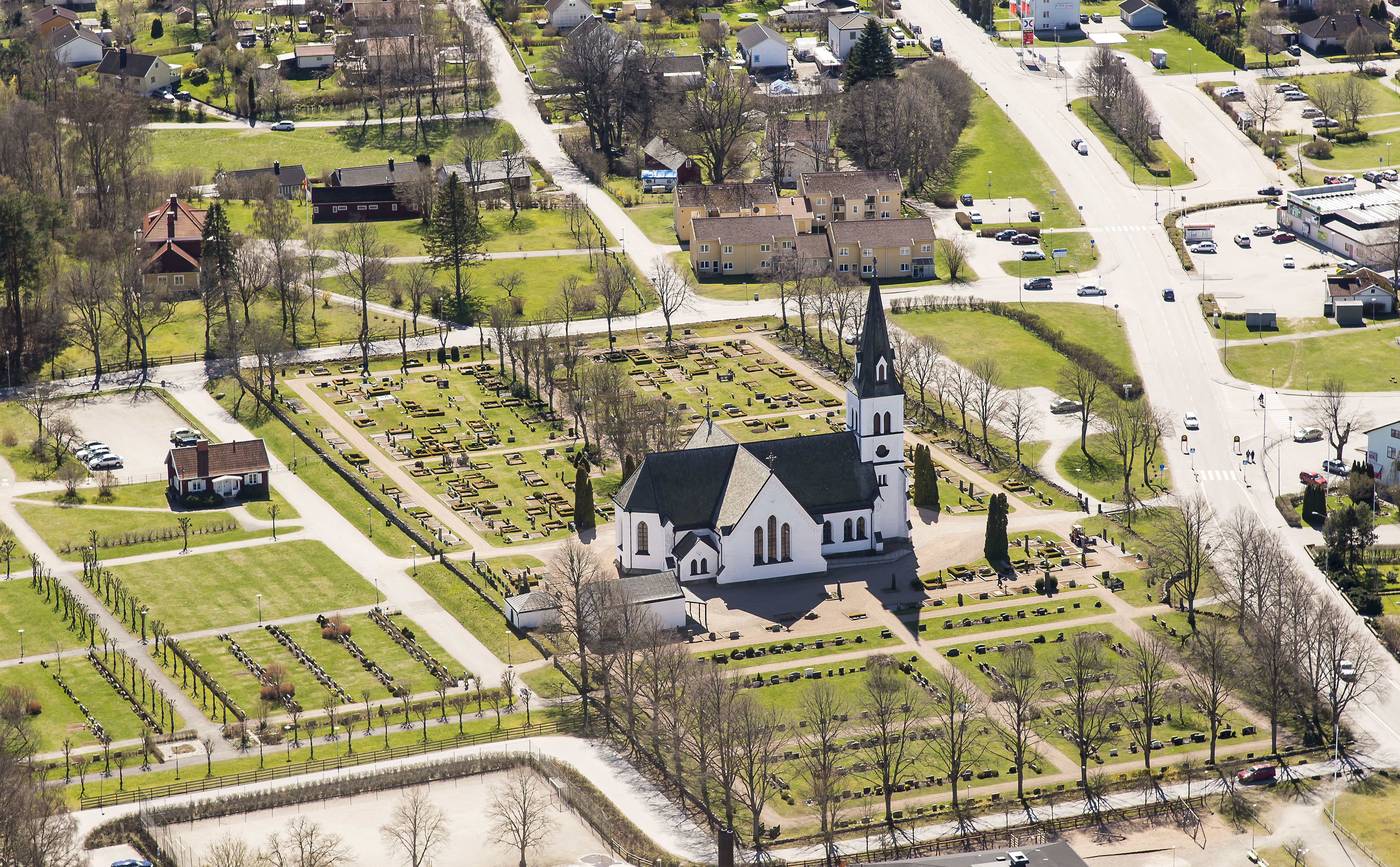 Vit kyrka med korsarm och högt torn.