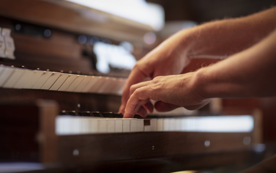 Närbild på någon som spelar orgel.