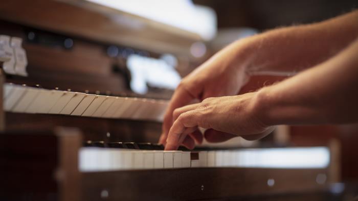 Närbild på någon som spelar orgel.