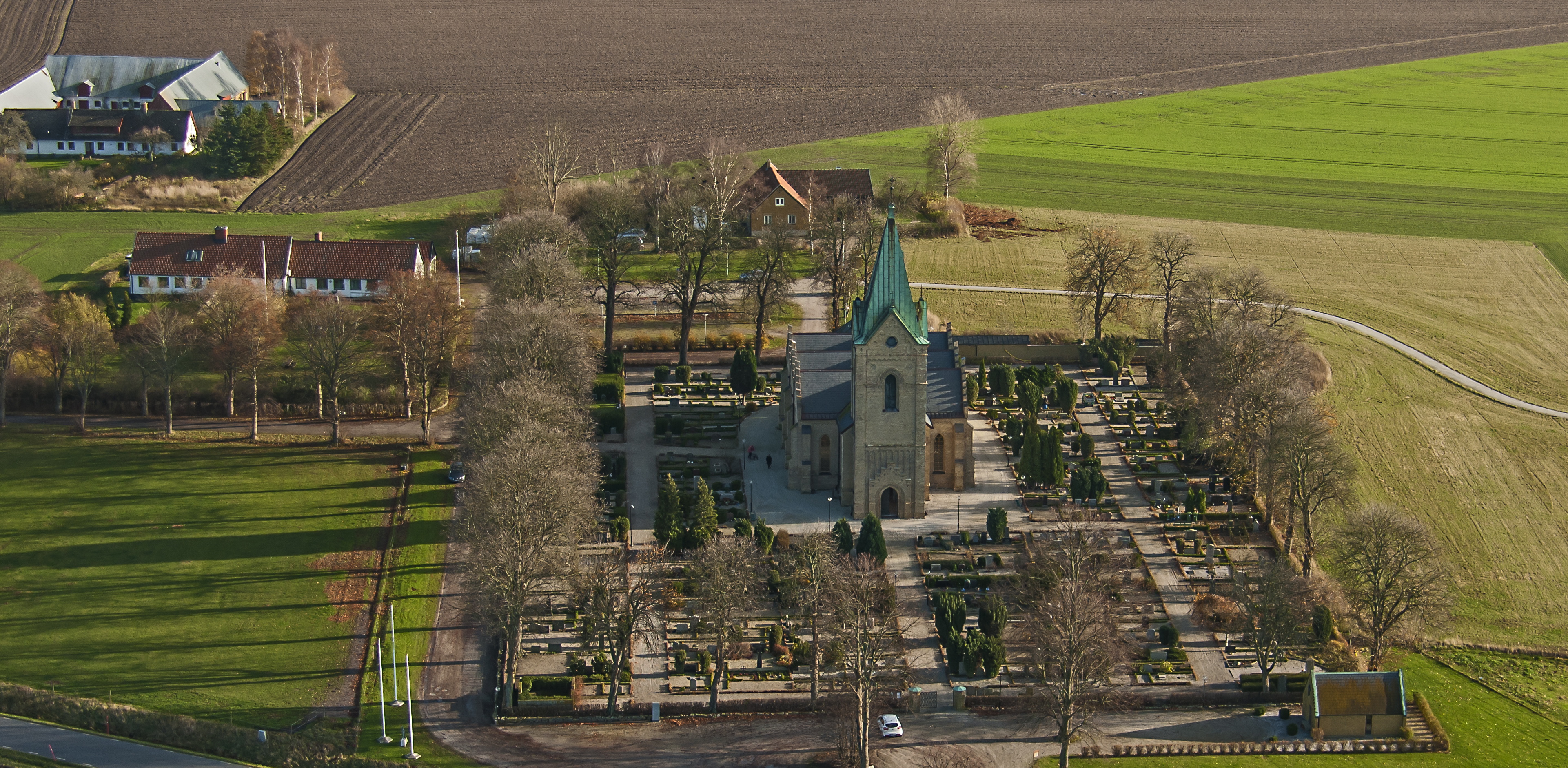 Ljus tegelkyrka med tre korsarmar och trappstensgavlar.