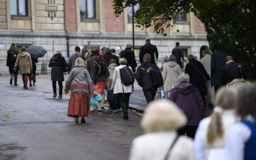 En stor grupp människor är på väg upp till Uppsala universitetshuset.