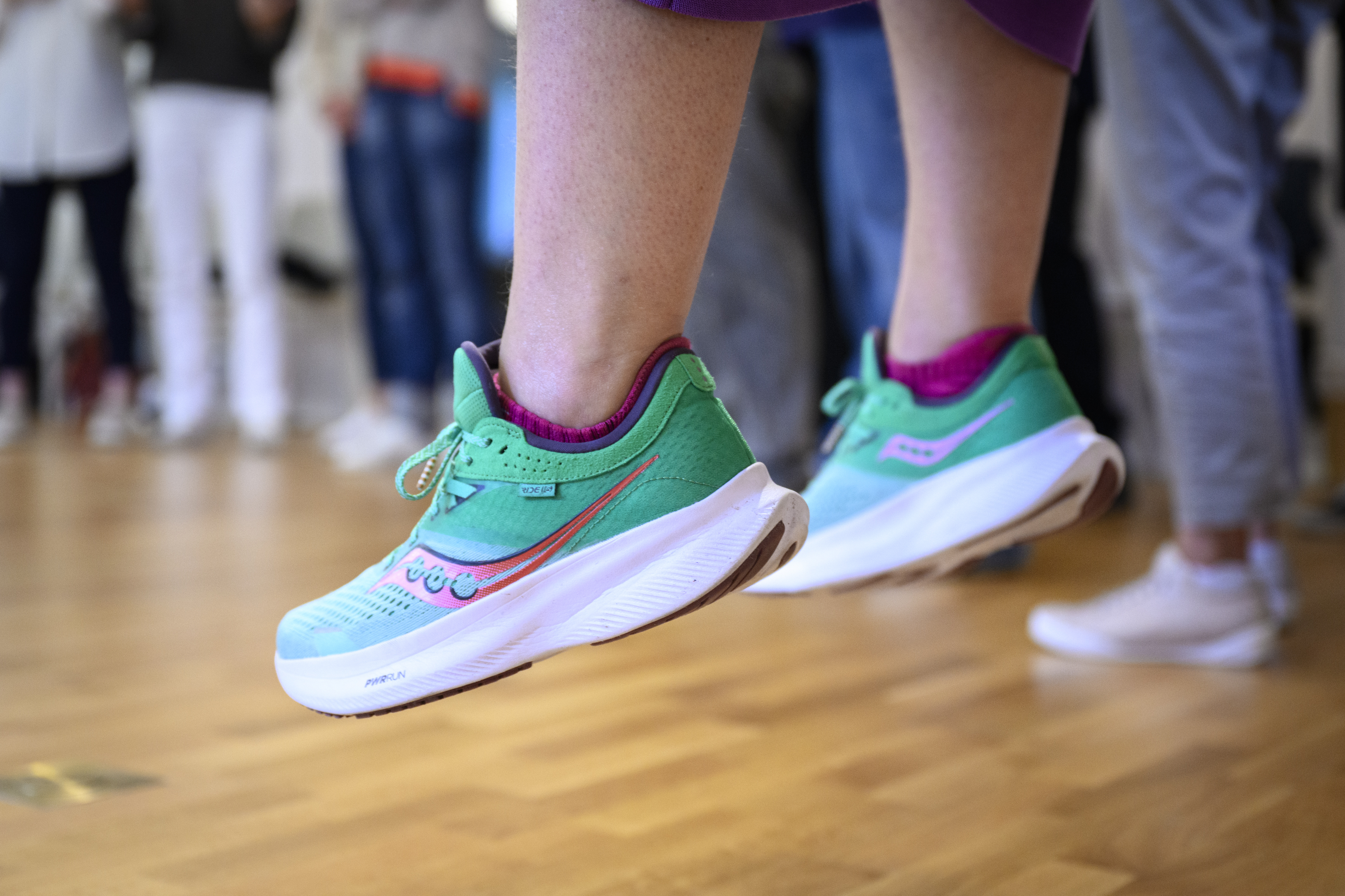 Närbild på någon som hoppar i turkosa gympaskor.