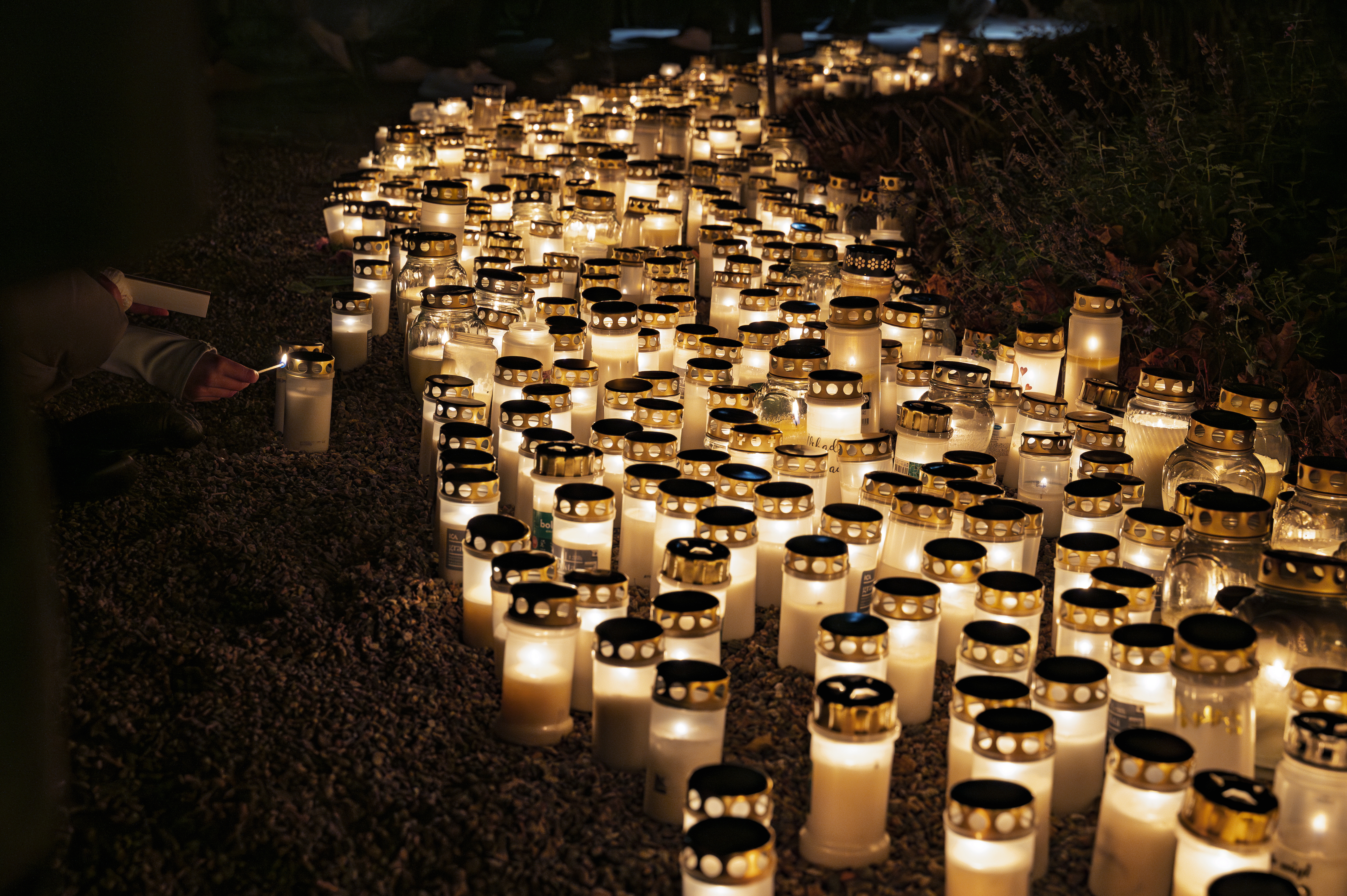 Hundratals gravljus lyser på en minneslund.