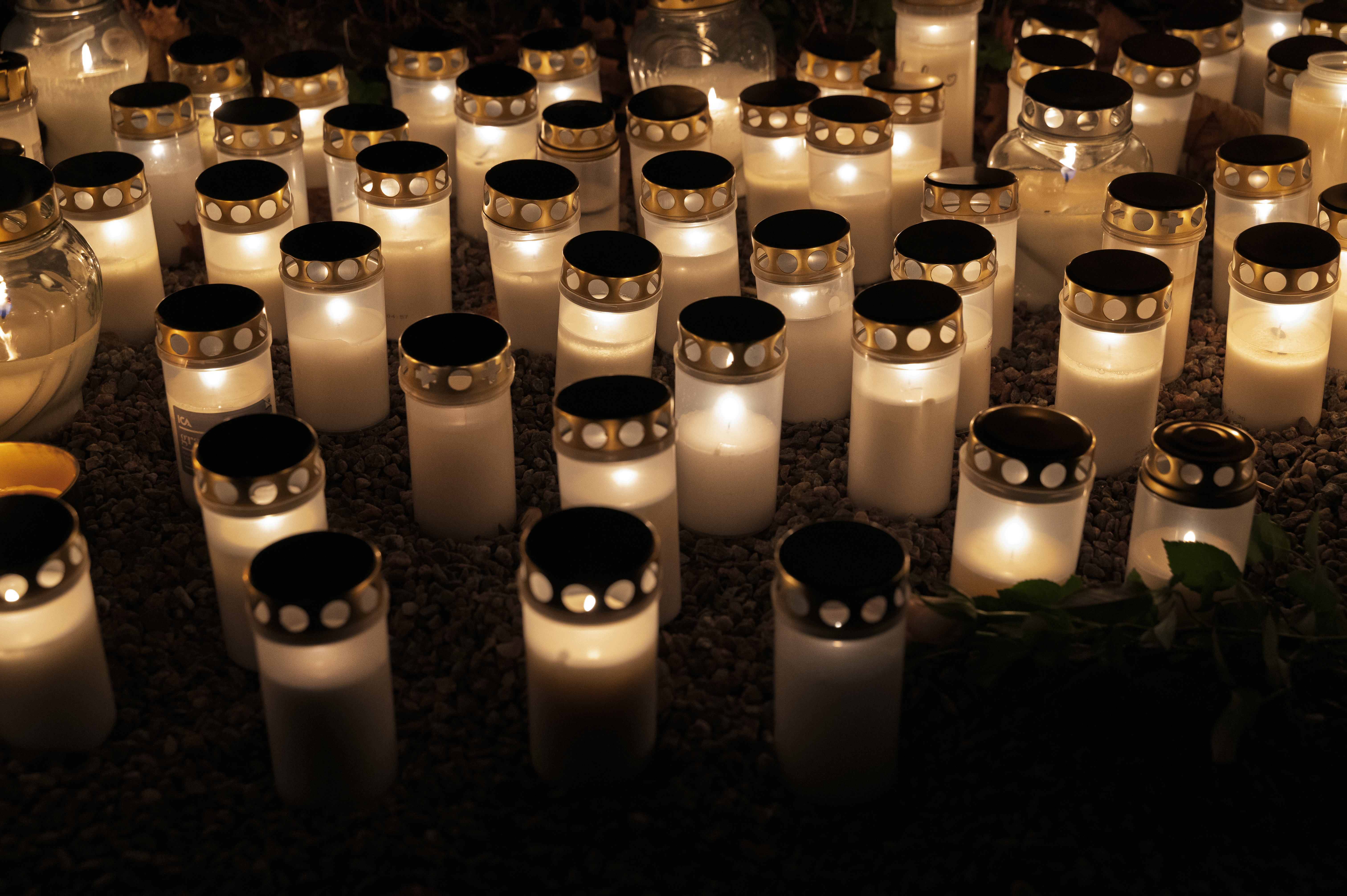 En massa gravljus lyser på en minneslund.