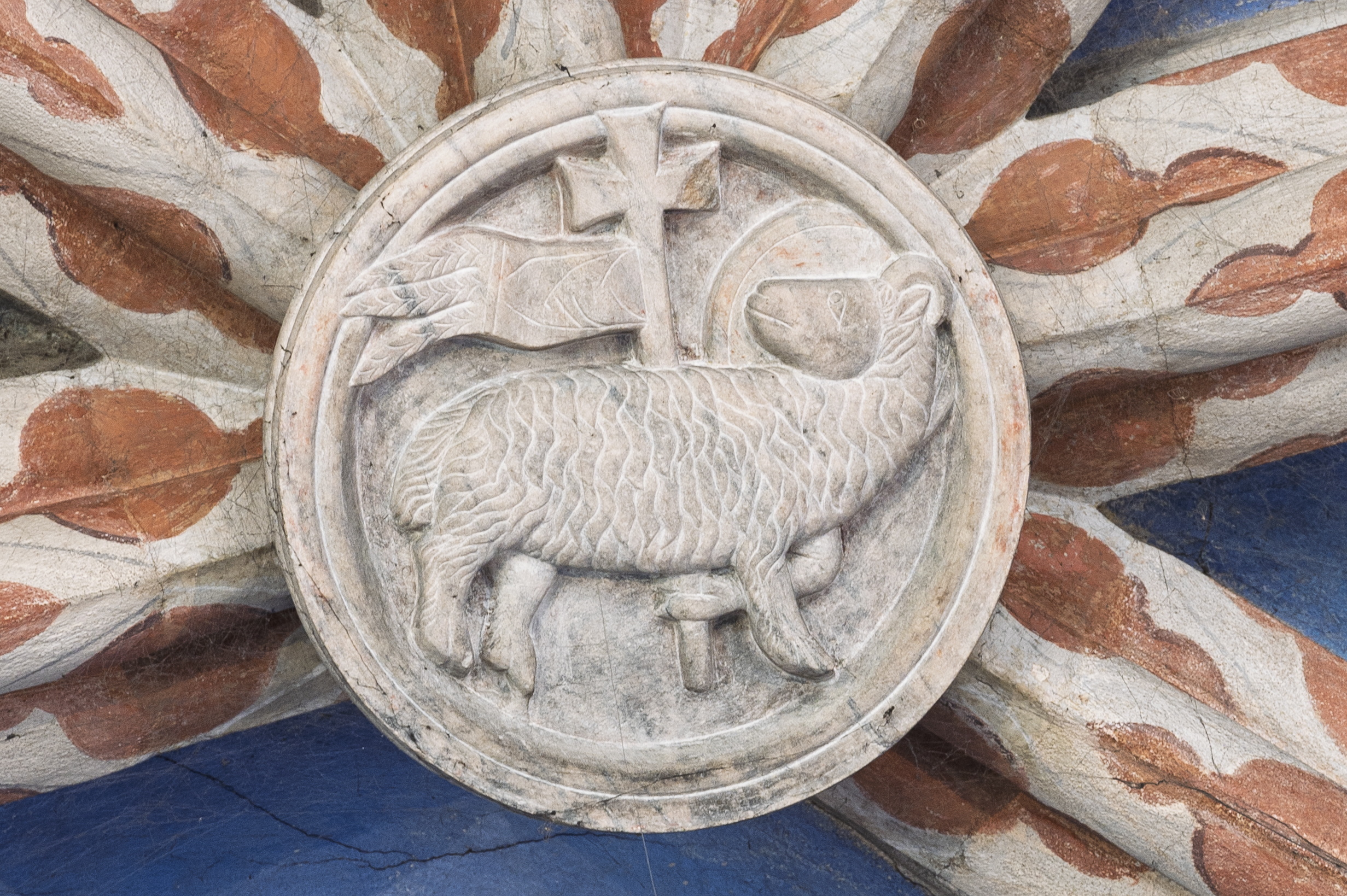 Närbild på Guds lamm gjord i sten.